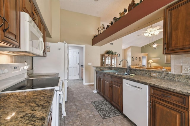 kitchen featuring white appliances, dark tile patterned floors, ceiling fan, sink, and dark stone countertops