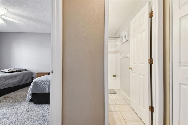 interior space with tile patterned flooring, a textured ceiling, and ceiling fan