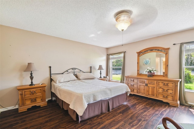 bedroom featuring a textured ceiling, ceiling fan, and dark wood-type flooring