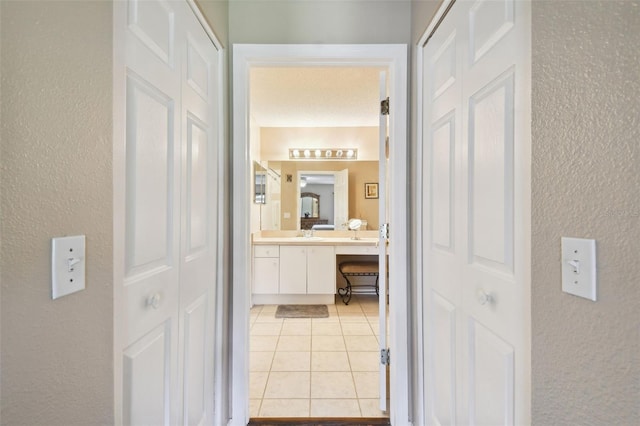 corridor with light tile patterned floors and sink