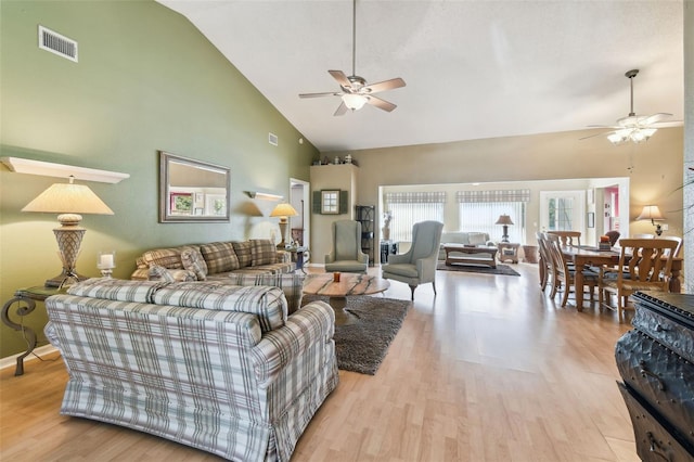 living room with ceiling fan, light hardwood / wood-style floors, and lofted ceiling