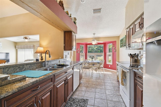 kitchen featuring appliances with stainless steel finishes, a textured ceiling, ceiling fan, sink, and light tile patterned floors