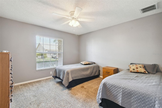 bedroom featuring carpet flooring, ceiling fan, and a textured ceiling