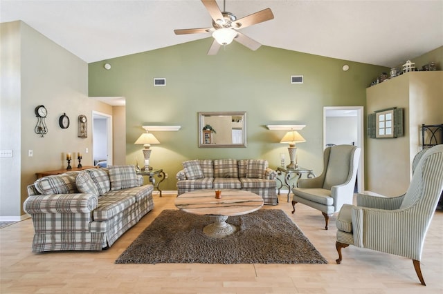 living room with ceiling fan, vaulted ceiling, and light wood-type flooring