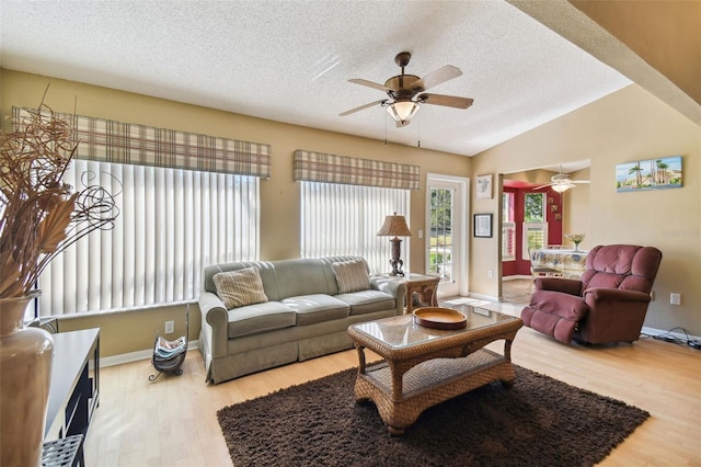 living room with hardwood / wood-style floors, ceiling fan, lofted ceiling, and a textured ceiling