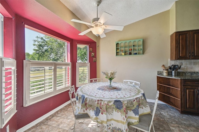 dining room with a textured ceiling, tile patterned floors, ceiling fan, and lofted ceiling