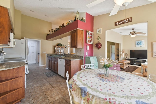 tiled dining area featuring a textured ceiling, ceiling fan, and sink