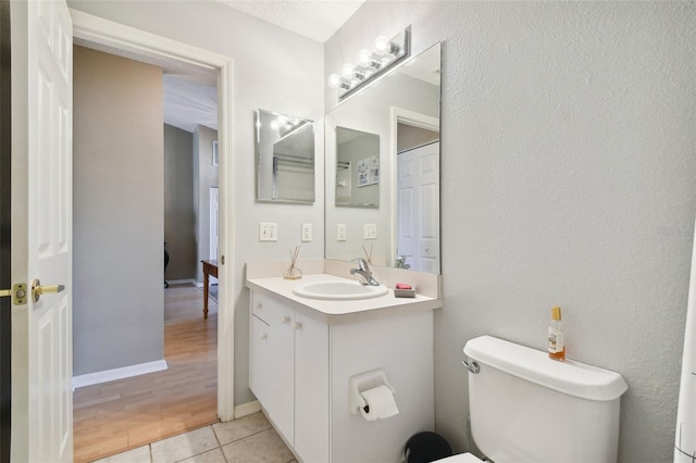 bathroom with tile patterned flooring, vanity, and toilet