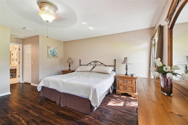 bedroom with connected bathroom, ceiling fan, dark hardwood / wood-style flooring, and a textured ceiling