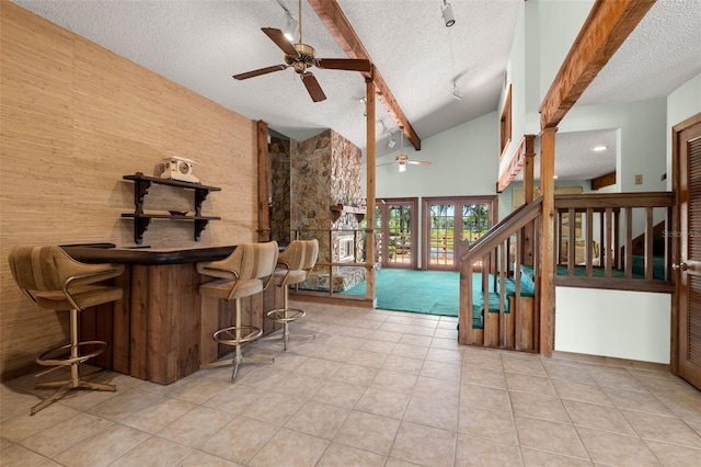 interior space featuring beamed ceiling, light tile patterned floors, and high vaulted ceiling