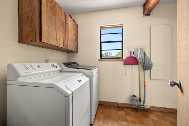 washroom with cabinets, separate washer and dryer, a textured ceiling, and light parquet floors