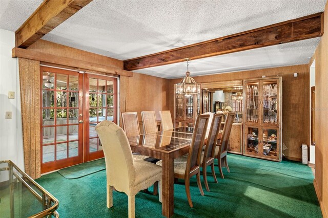 dining room featuring beamed ceiling, a notable chandelier, carpet, and french doors