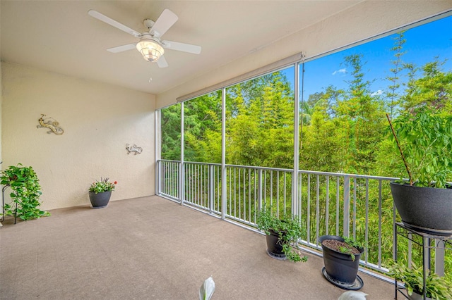 unfurnished sunroom featuring ceiling fan