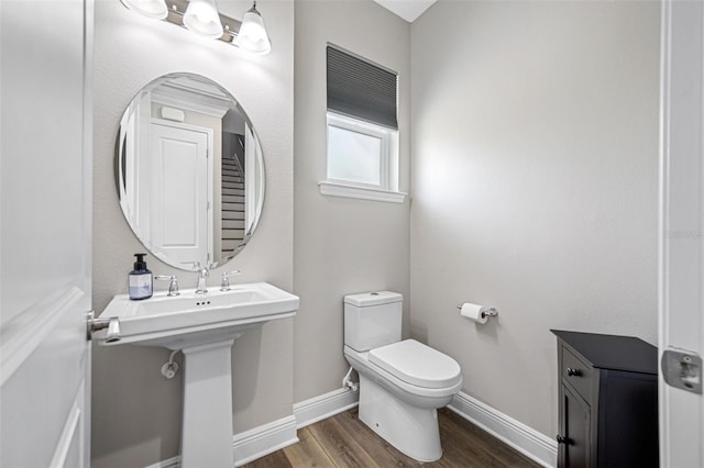 bathroom featuring hardwood / wood-style flooring, toilet, and sink