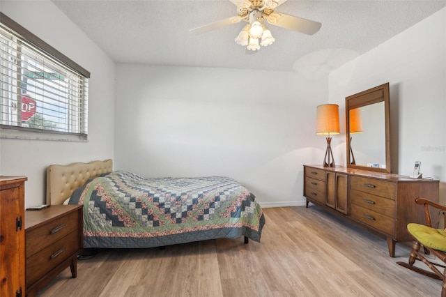 bedroom featuring a textured ceiling, ceiling fan, and light hardwood / wood-style flooring