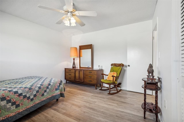 bedroom featuring a textured ceiling, ceiling fan, and light hardwood / wood-style floors