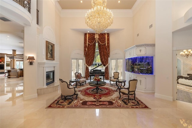 sitting room with a high ceiling, an inviting chandelier, and ornamental molding