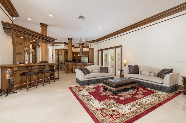 living room featuring crown molding, bar, and decorative columns