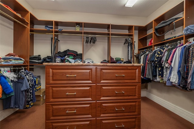 walk in closet featuring dark carpet