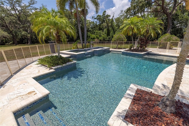 view of swimming pool with an in ground hot tub and a lawn