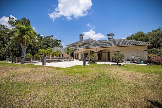 back of property with a patio and a lawn