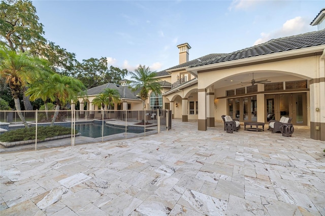 view of swimming pool with ceiling fan and a patio