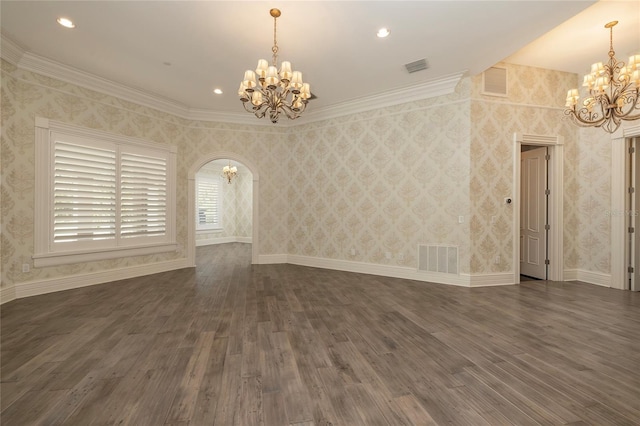 empty room featuring an inviting chandelier, visible vents, dark wood-style floors, and arched walkways