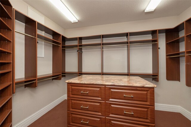 walk in closet featuring dark colored carpet