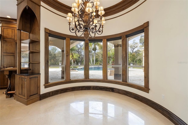 interior space featuring baseboards, an inviting chandelier, and crown molding