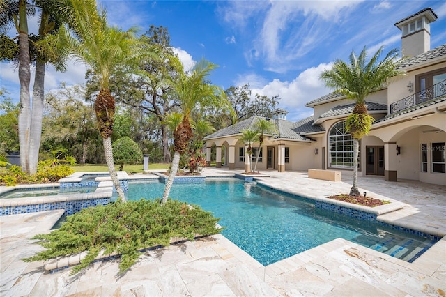 outdoor pool featuring a patio and an in ground hot tub