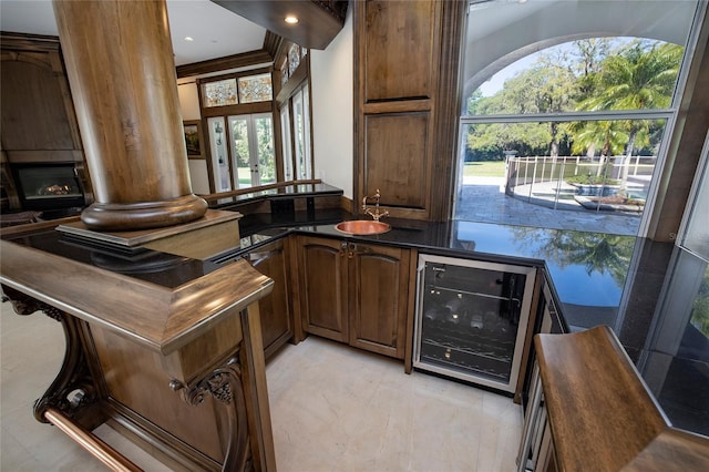 bar with wine cooler, a sink, marble finish floor, a fireplace, and indoor wet bar