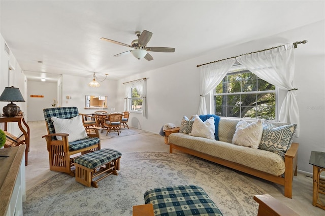 living room featuring carpet flooring, ceiling fan, and a healthy amount of sunlight