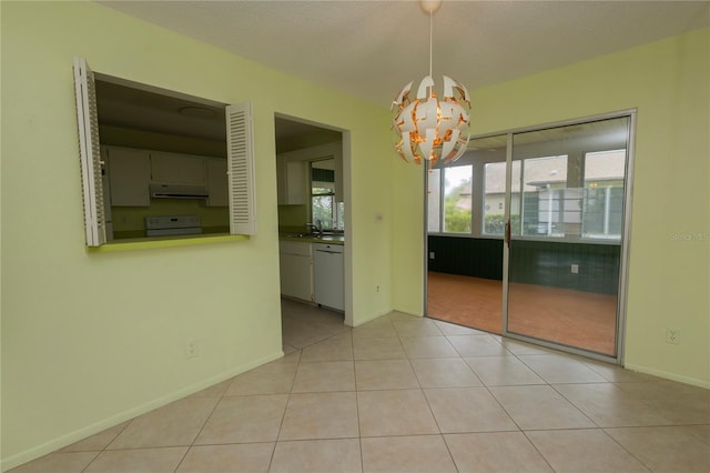 empty room with light tile patterned floors, sink, and a chandelier