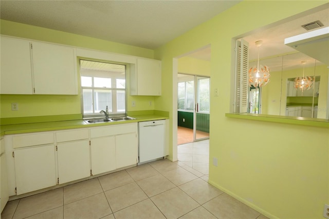 kitchen with white cabinets, dishwasher, pendant lighting, light tile patterned floors, and sink