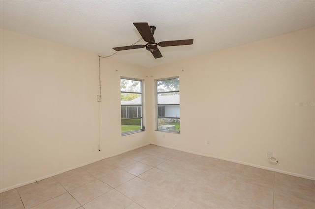 unfurnished room with ceiling fan, a textured ceiling, and light tile patterned floors