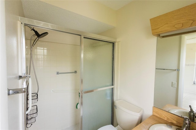 bathroom with a shower with door, toilet, and sink