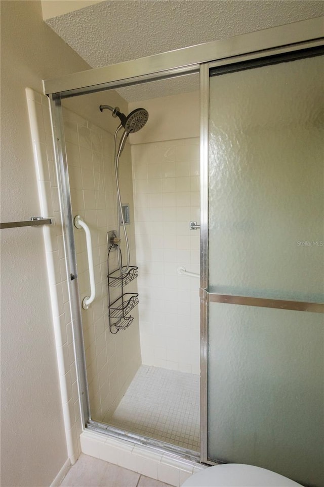 bathroom with toilet and a shower with door