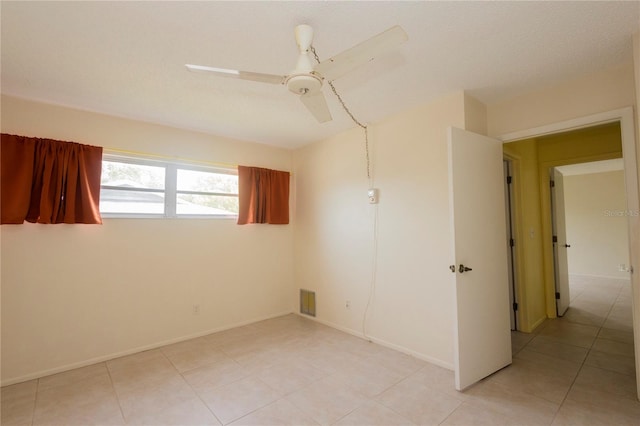 empty room featuring light tile patterned flooring and ceiling fan