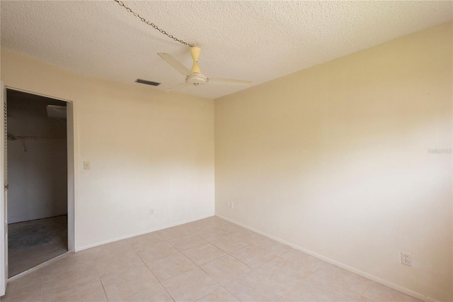 unfurnished bedroom featuring ceiling fan, light tile patterned flooring, a spacious closet, and a closet