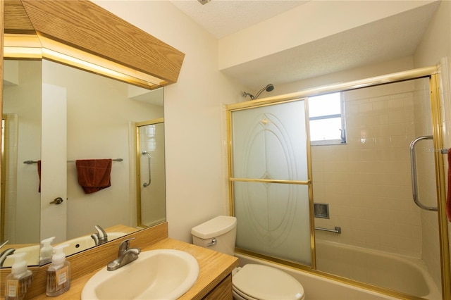 full bathroom featuring a textured ceiling, toilet, bath / shower combo with glass door, and vanity