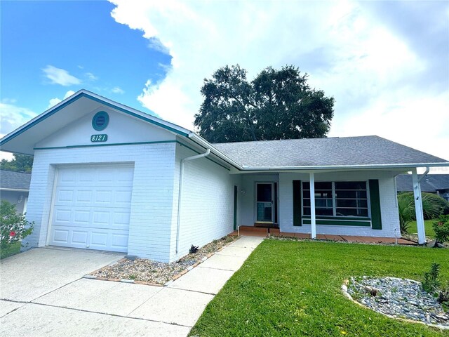 single story home featuring a front lawn and a garage