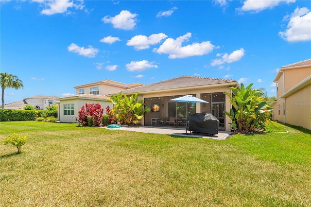 back of house featuring a patio area and a lawn