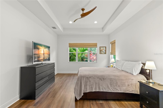 bedroom featuring a tray ceiling and hardwood / wood-style floors