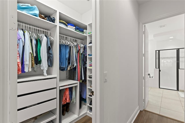 spacious closet with light tile floors