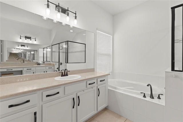 bathroom with vanity with extensive cabinet space, tile flooring, and independent shower and bath