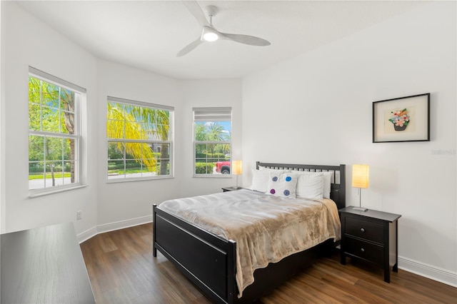 bedroom with ceiling fan, dark hardwood / wood-style floors, and multiple windows