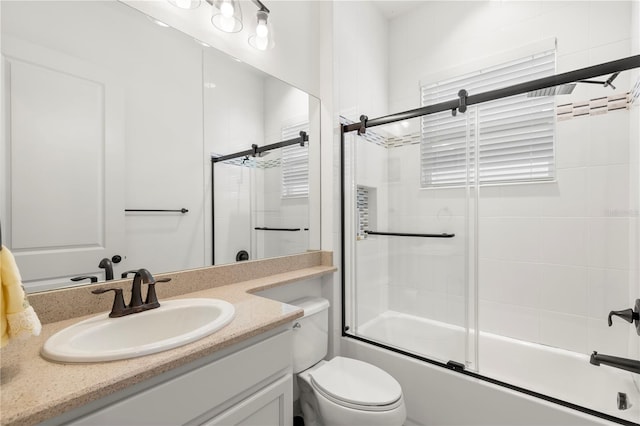 full bathroom featuring enclosed tub / shower combo, oversized vanity, and toilet