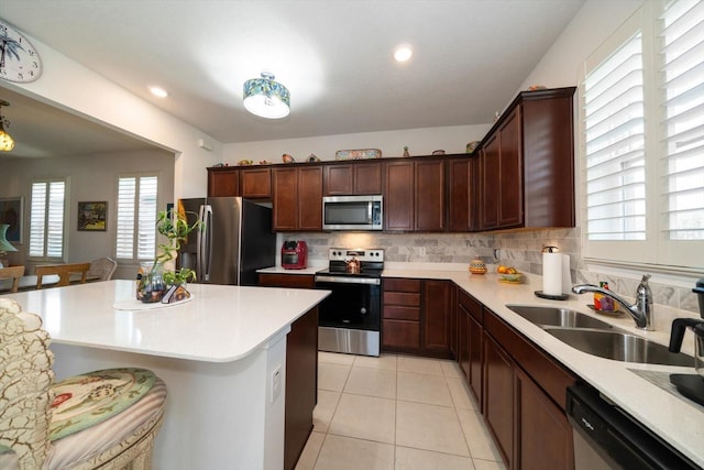 kitchen featuring sink, decorative backsplash, stainless steel appliances, and light tile patterned floors