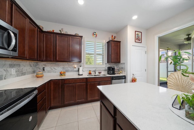 kitchen featuring tasteful backsplash, stainless steel appliances, sink, and light tile patterned floors