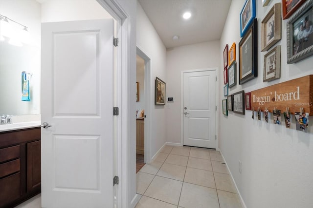 corridor with light tile patterned flooring and sink